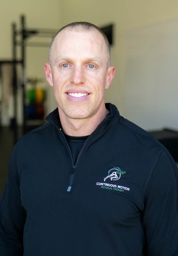 A man in a black shirt standing in a gym.